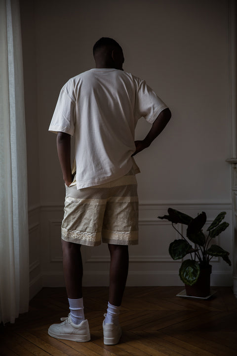 Thierno is wearing White Canvas sustainable natural cotton jersey oversized, genderless, seasonless t-shirt, one size. The natural cotton jersey t-shirt has minimal modern aesthetics design allowing comfort and bringing self-confidence. This unique piece is made locally in Paris to reduce environmental impact and guarantee high quality and durability of the products. 